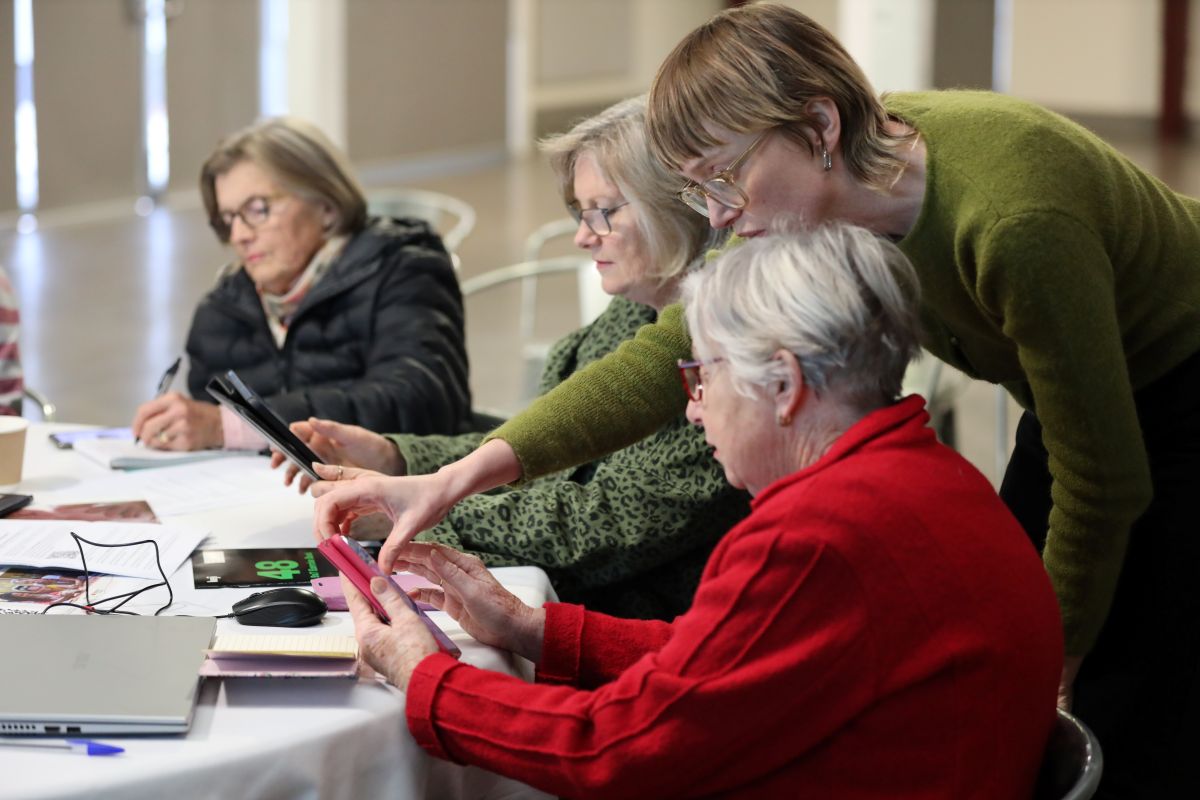 Women in rural community looking at devices.